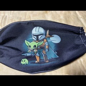 Mando holding baby Yoda Mask